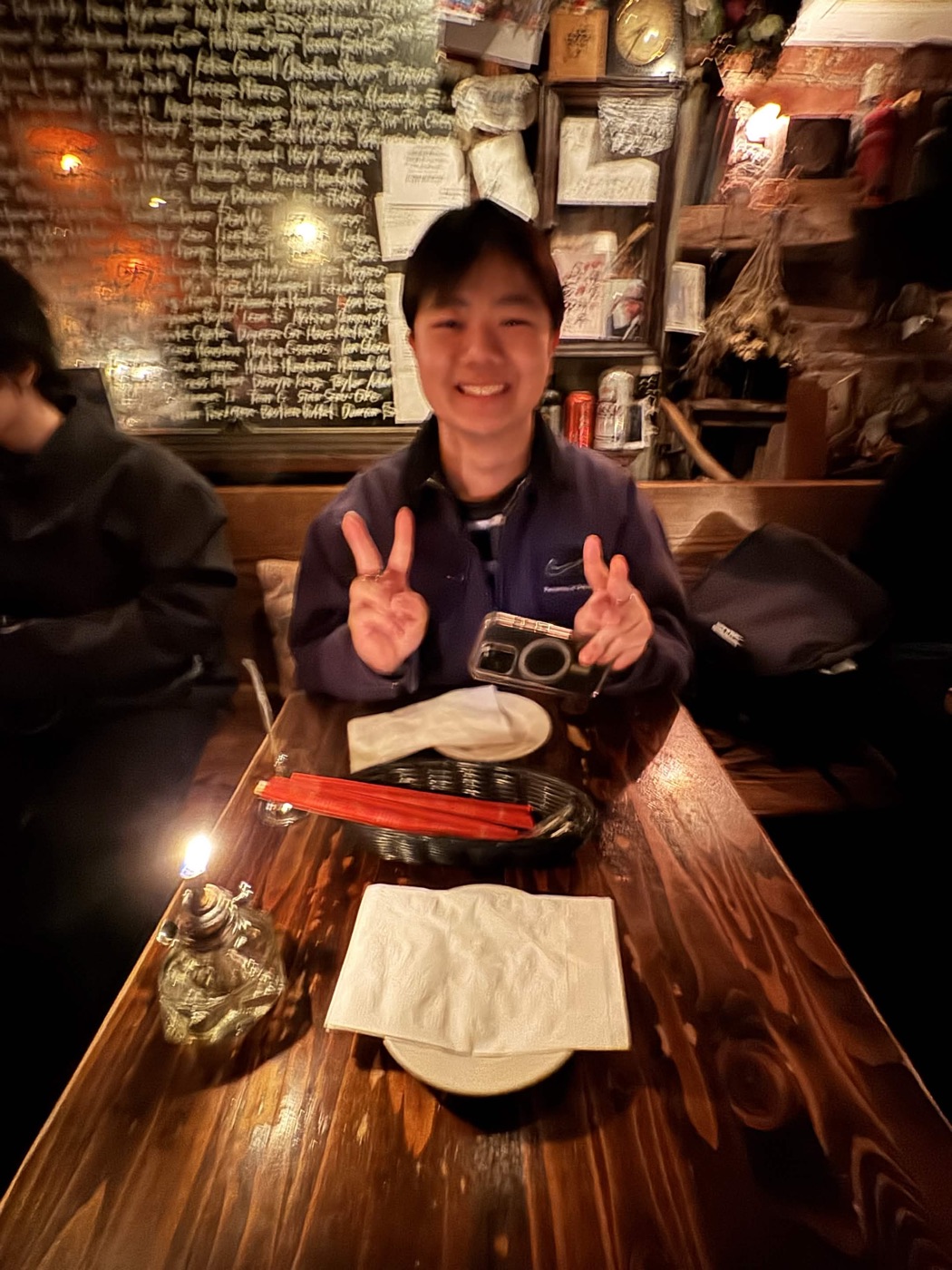 Morris making peace signs at a candlelit restaurant table